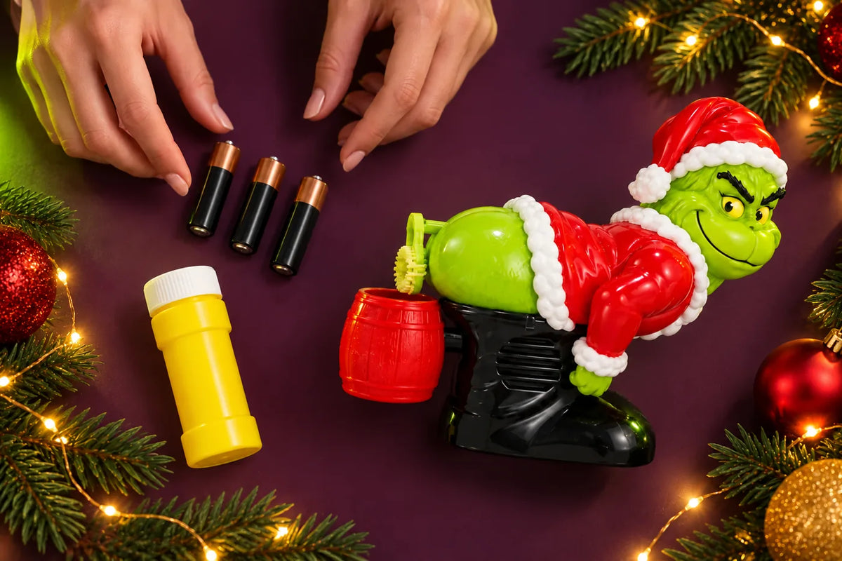 Preparing the Grinch with three AA batteries and bubble solution.